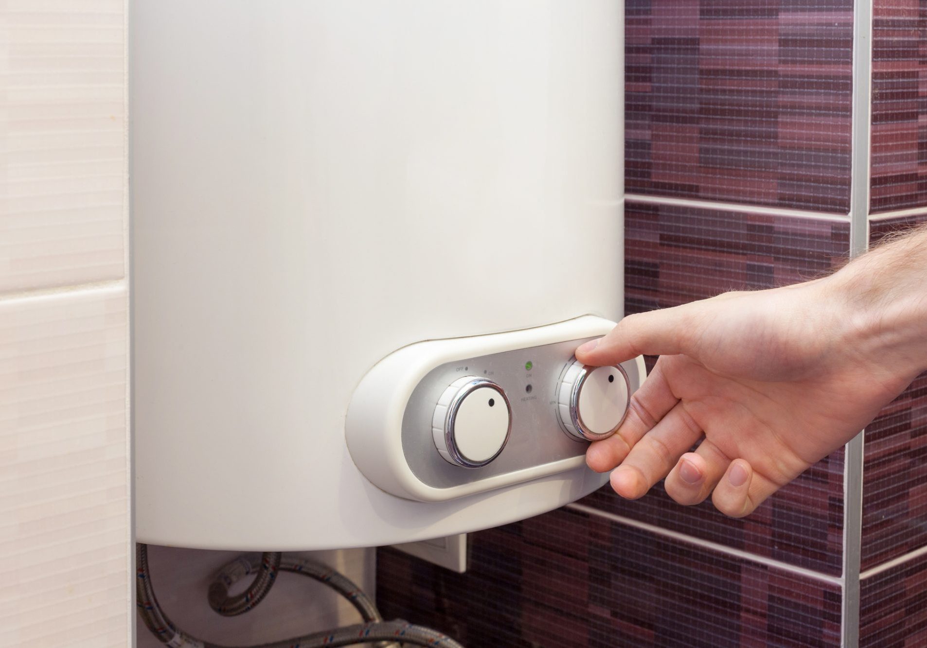 Close-up of man hands setting the temperature of water in Electric Boiler